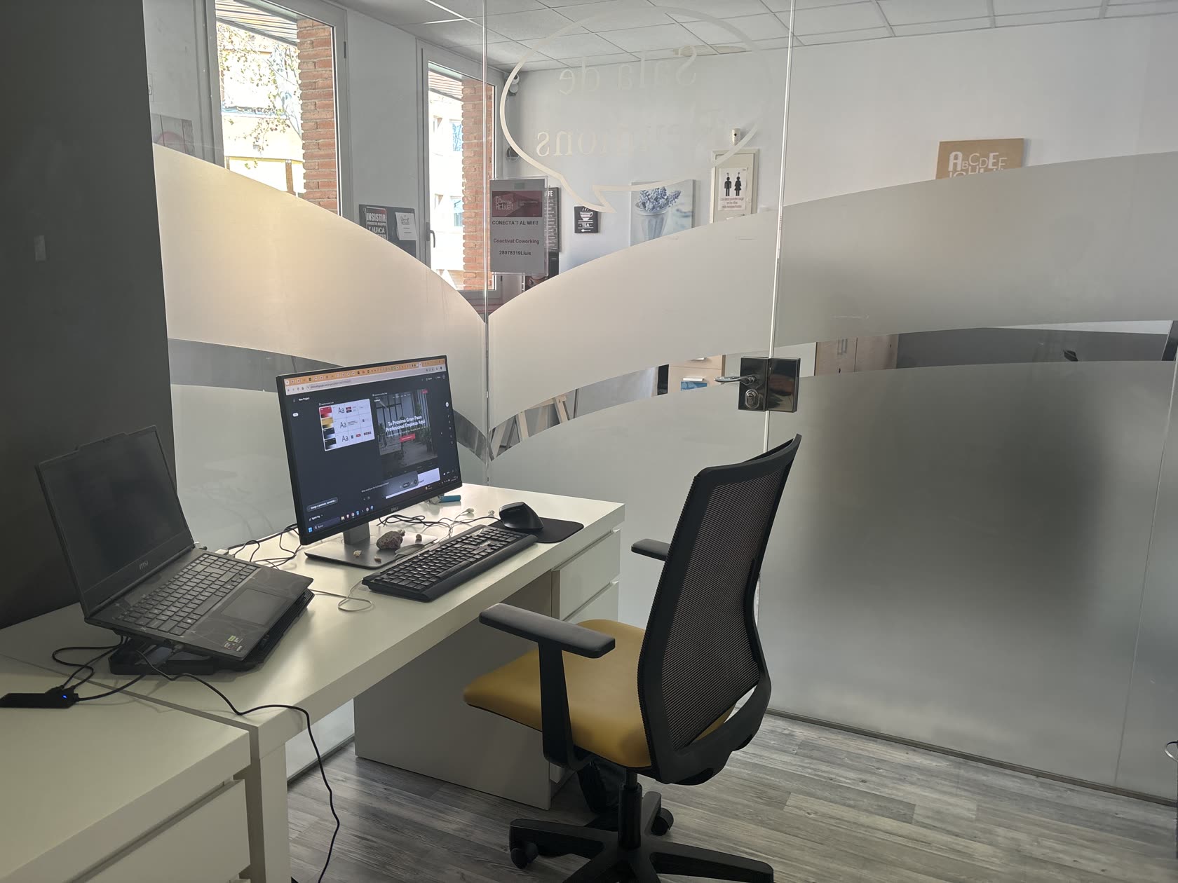 Zona de treball del coworking CoActiva't amb escriptoris i monitors