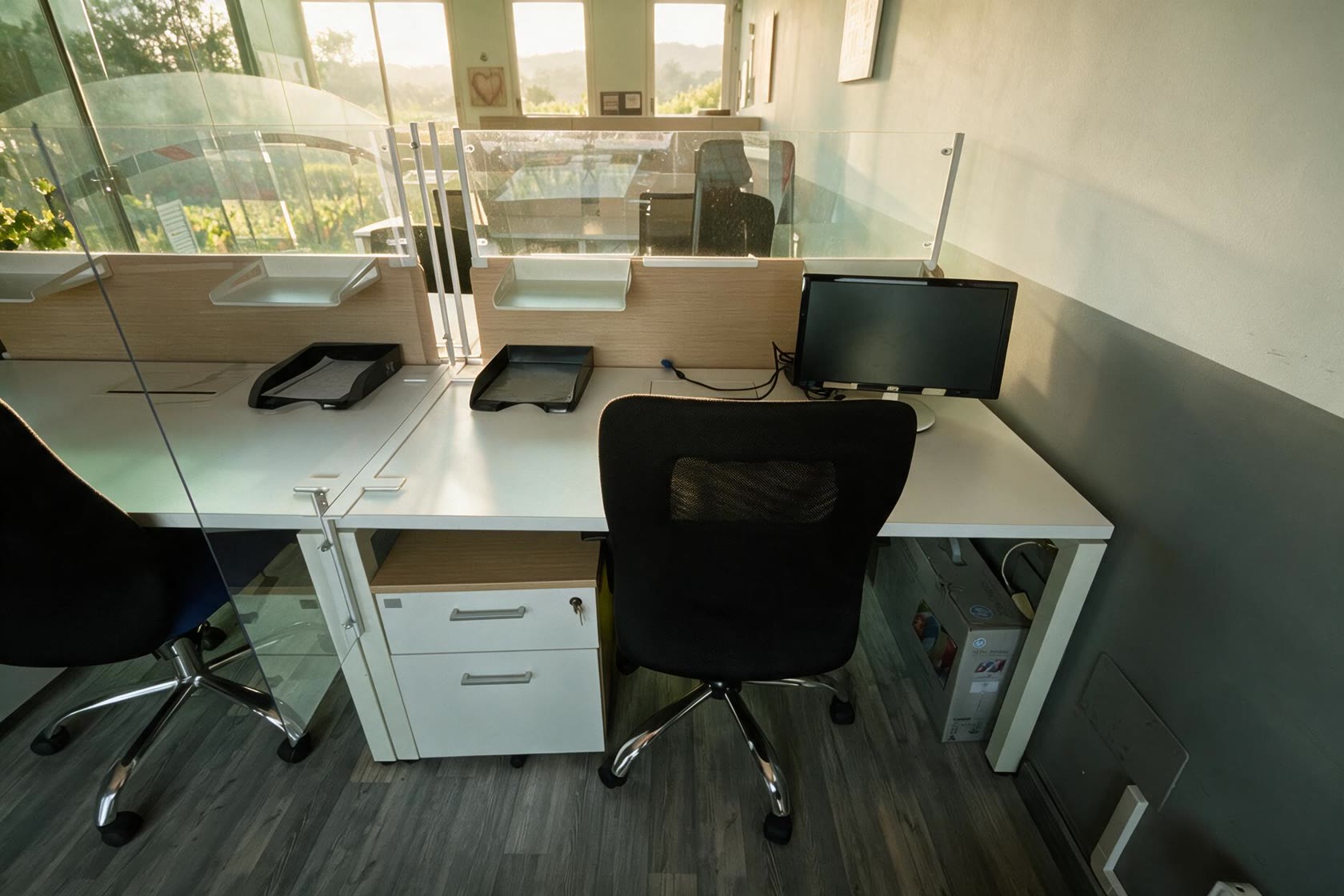 Lloc de treball del coworking CoActiva't amb llum natural de matí i vegetació al fons