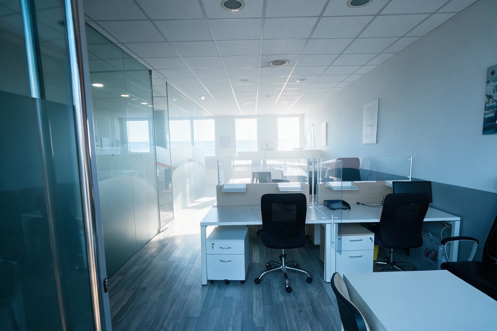Interior del coworking CoActiva't amb llum natural i llocs de treball